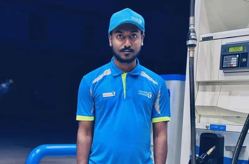 Arafat in his blue Oman Oil uniform on duty at a fuel pump